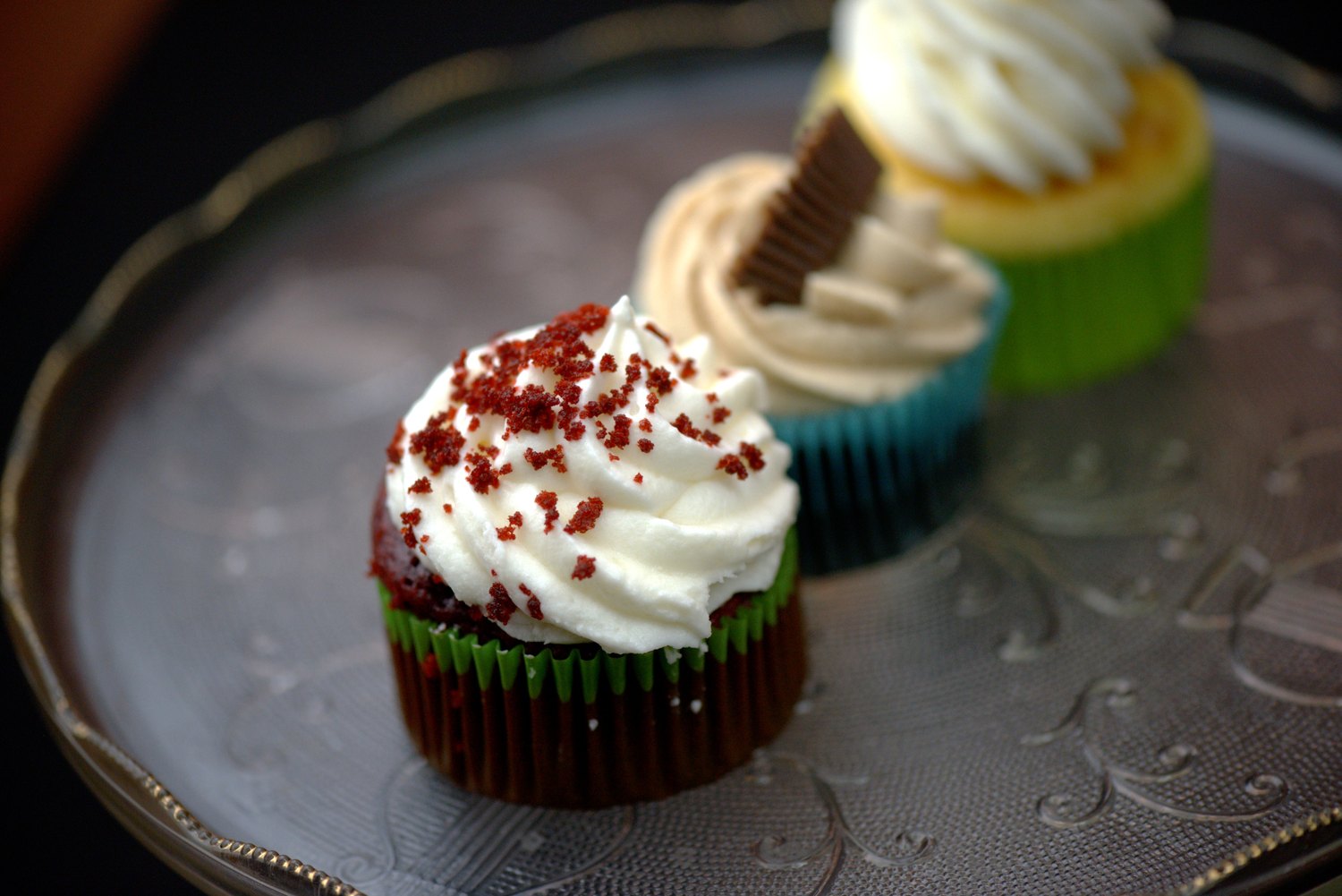 Red velvet, Reese's peanut butter, and lemon cupcakes on a silver stand