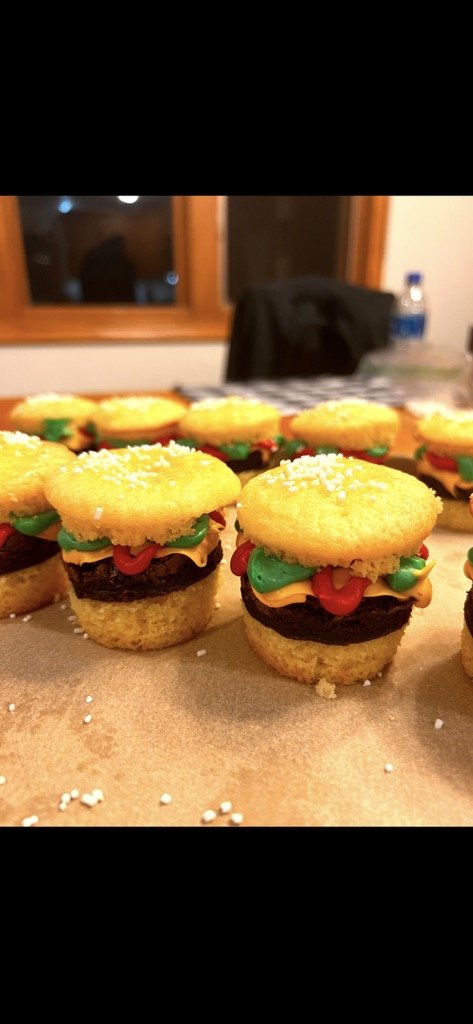 Cheeseburger-themed cupcakes with frosting fixings and sesame sprinkles